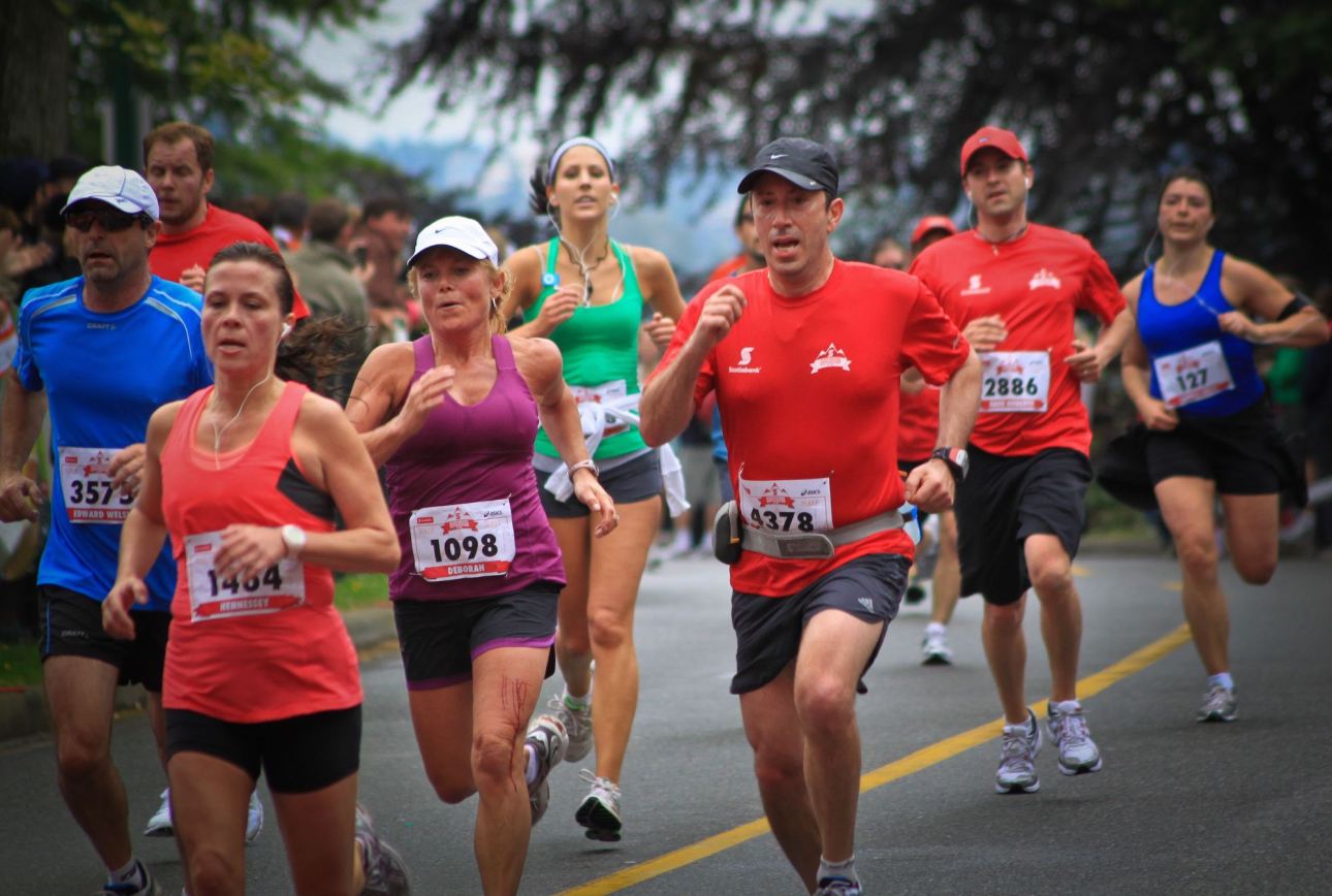 Groupe de coureurs sur route pendant un marathon, dossards sur le maillot