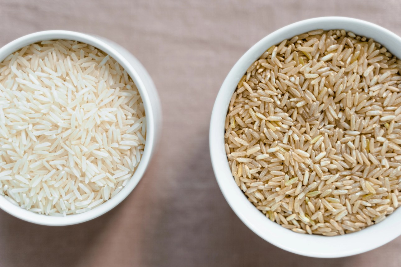 Deux bols vus de dessus, l'un de riz blanc, l'autre de riz complet